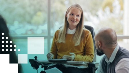 A woman in a wheelchair talking to a man